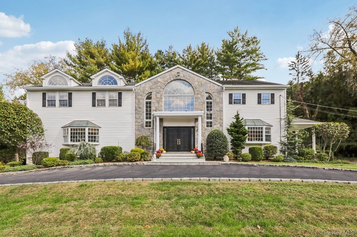 View of front of property with a front lawn and stone siding