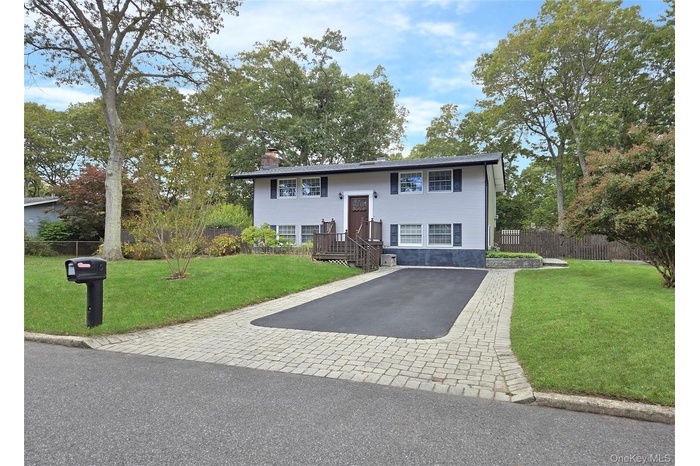 Raised ranch with a chimney and driveway