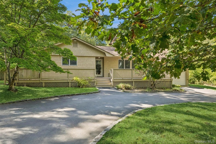 View of front of property featuring a circular driveway and porch
