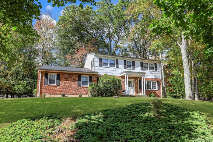 View of front of home with brick siding, a front lawn