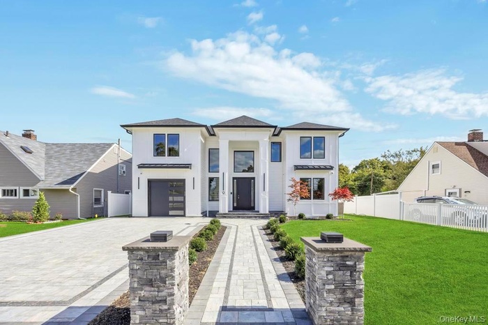 View of front of property with decorative driveway and an attached garage
