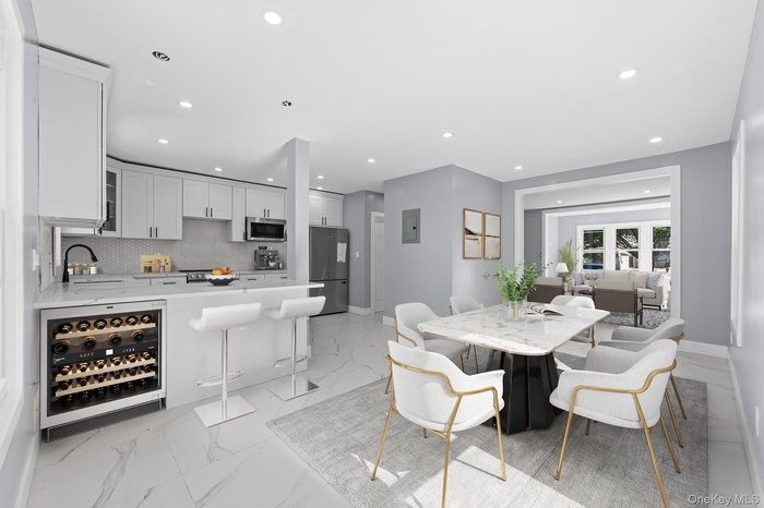 Dining area featuring wine cooler, light marble finish flooring, recessed lighting, and electric panel