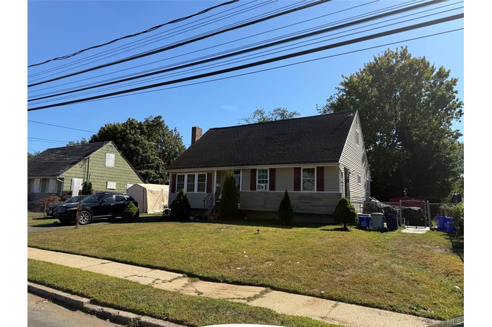 View of front of house featuring a chimney and a shingled roof