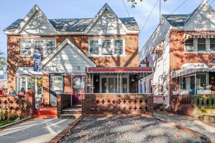 View of front of home with brick siding and a porch