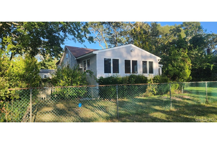 View of property exterior with a fenced backyard and roof with shingles