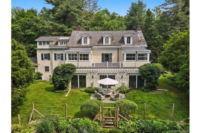 Back of house featuring a chimney, a yard, a patio area, and an outdoor hangout area