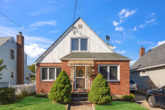 Bungalow-style house featuring brick siding, board and batten siding, and roof with shingles