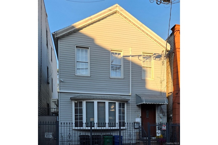 View of front of home with a fenced front yard and a gate