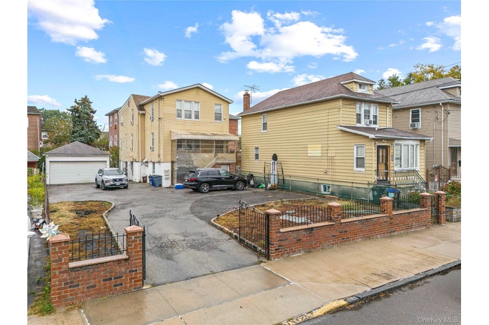 View of front of house with a fenced front yard, a residential view, and a detached garage