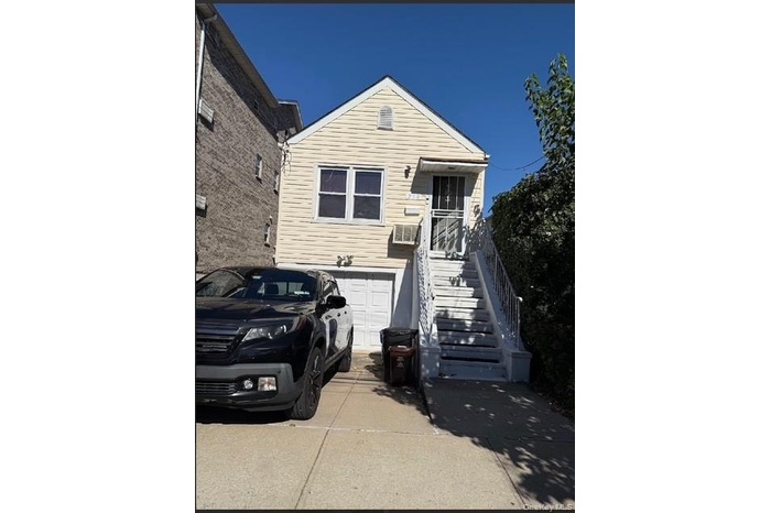 View of front facade with stairs, a garage, and concrete driveway