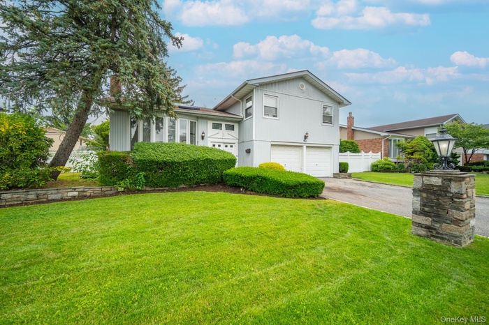 View of front of property featuring a garage and asphalt driveway