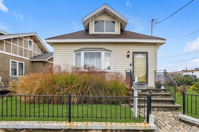 View of front of home featuring a fenced front yard and roof with shingles