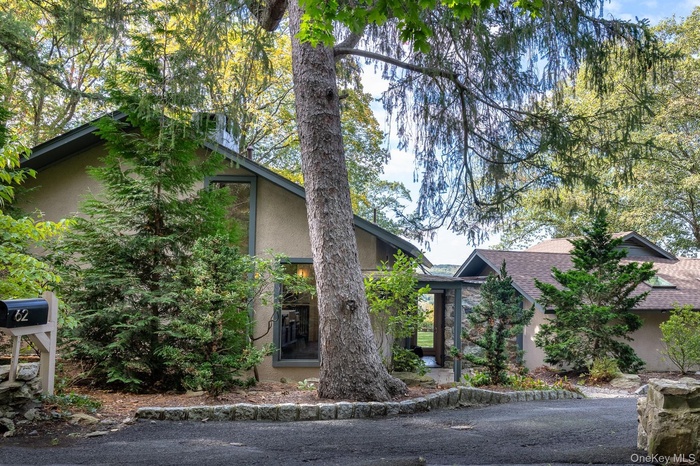 Mid-century modern home with stucco siding and roof with shingles