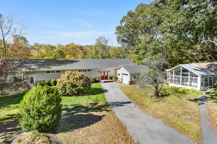 Single story home with driveway, a front yard, and an attached garage