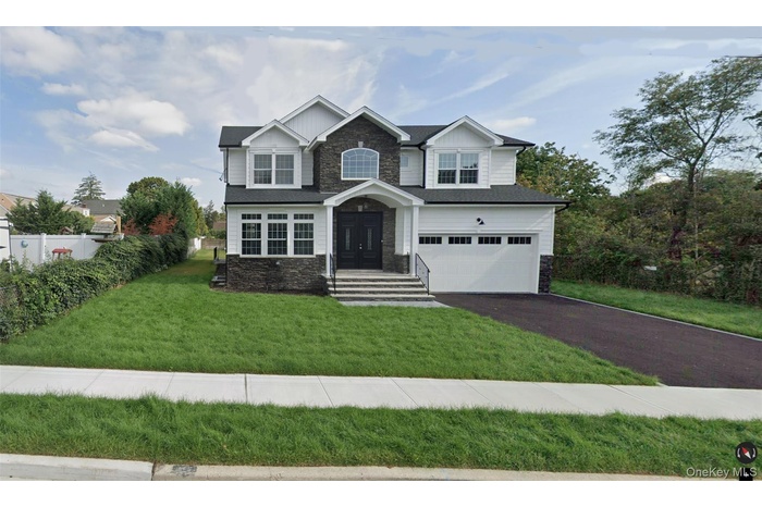 Craftsman-style house with a garage, board and batten siding, driveway, and stone siding