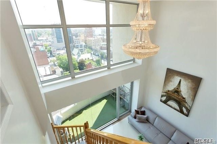 Stairway with a city view and a towering ceiling