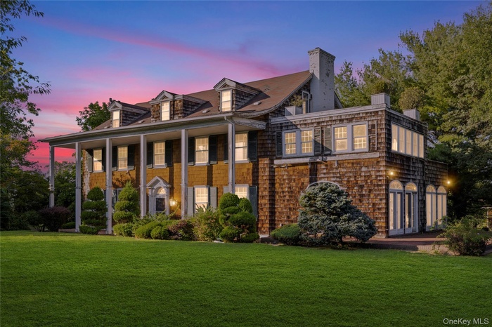 View of front of house featuring a yard, covered porch, and a chimney