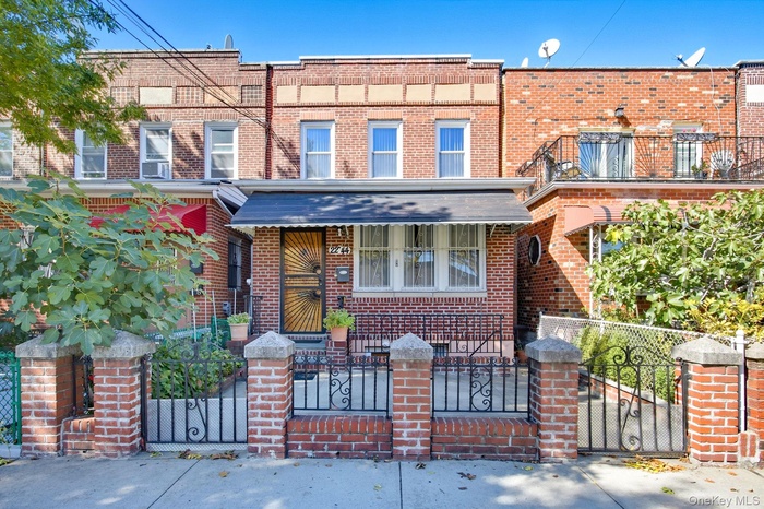 Traditional home with brick siding and a fenced front yard