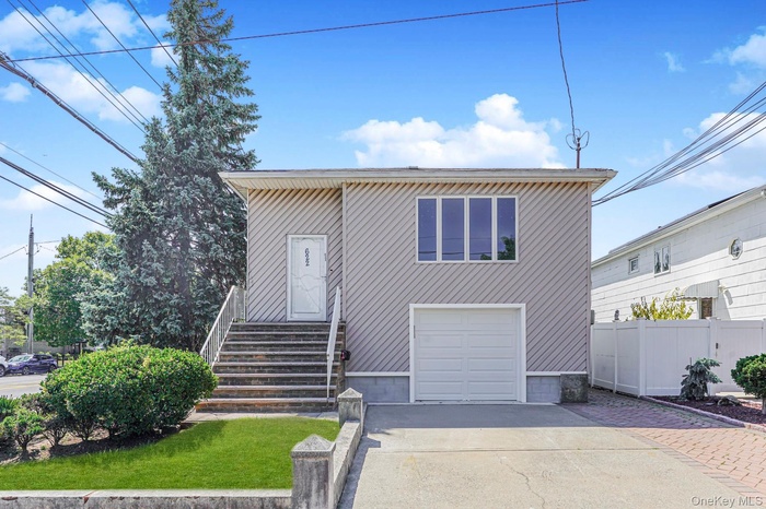 View of front of house featuring concrete driveway and a garage