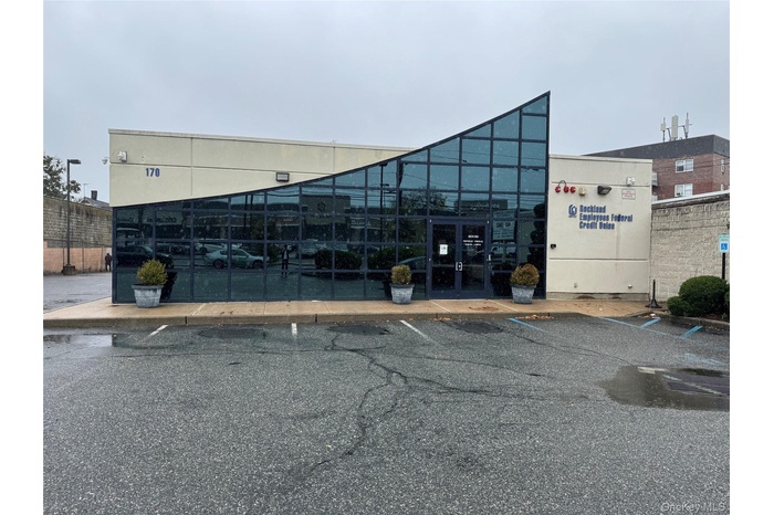 View of building exterior with uncovered parking
