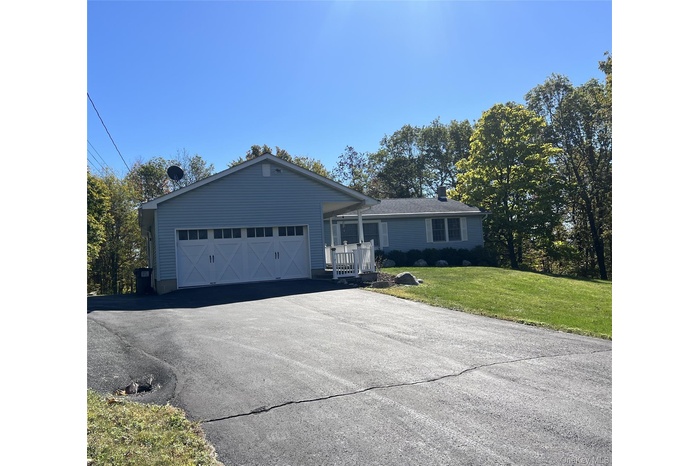 Ranch-style home featuring a front yard and asphalt driveway