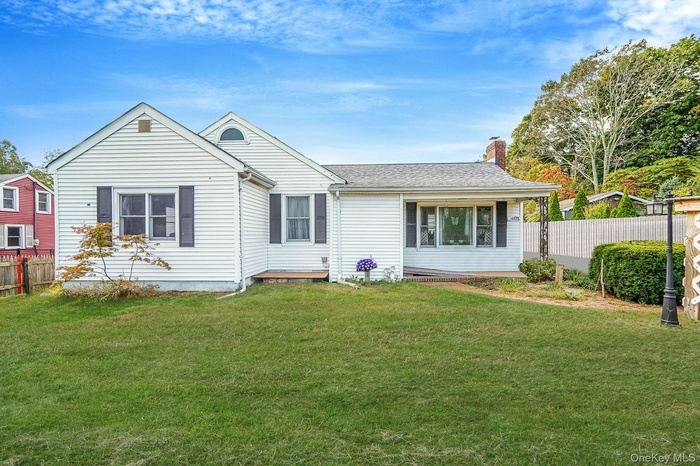 View of front facade featuring a chimney and a shingled roof