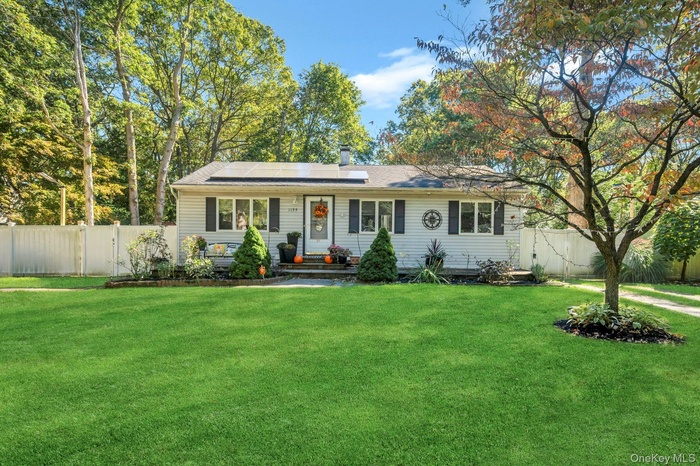 Single story home featuring a chimney, solar panels, and a gate