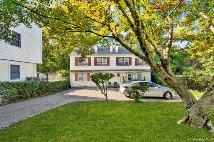 Colonial-style house with a front lawn and driveway