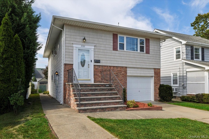 View of front of home featuring brick siding, concrete driveway, and an attached garage