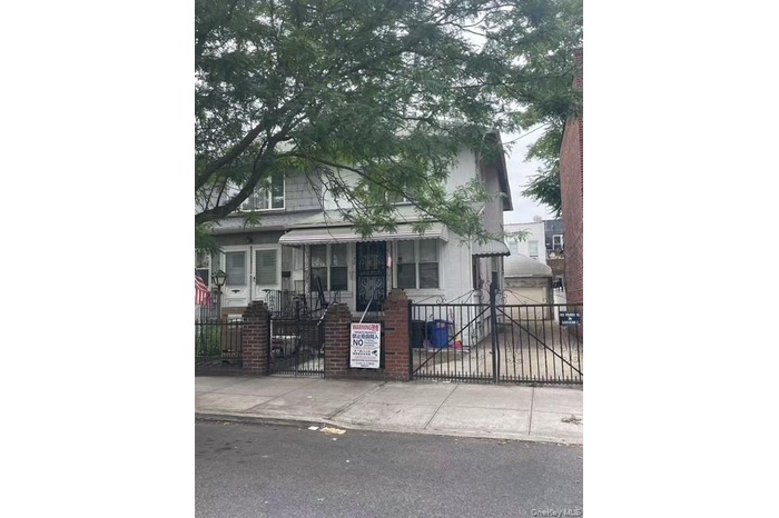 View of front facade with a fenced front yard and a gate