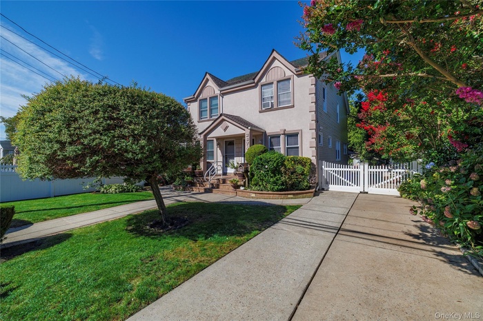 View of front of house with stucco siding and a gate