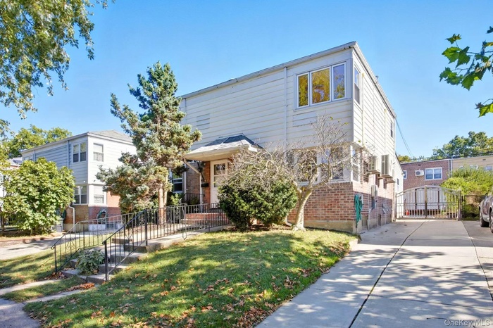 View of front of home with brick siding and a gate