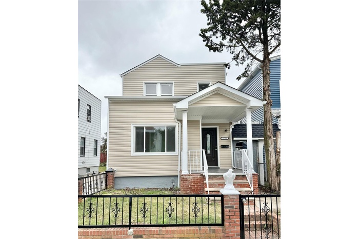 View of front of home with covered porch and a fenced front yard