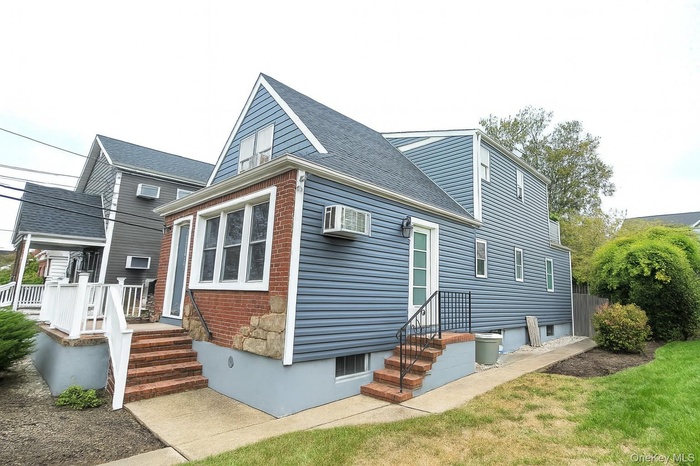 Rear view of house featuring roof with shingles and a yard