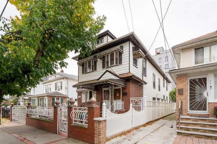 Traditional style home with a fenced front yard, a gate, and brick siding