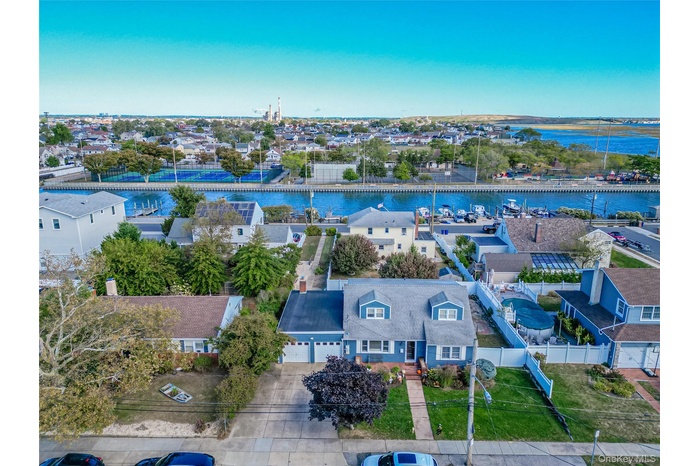 Aerial perspective of suburban area featuring a large body of water and a notable bridge