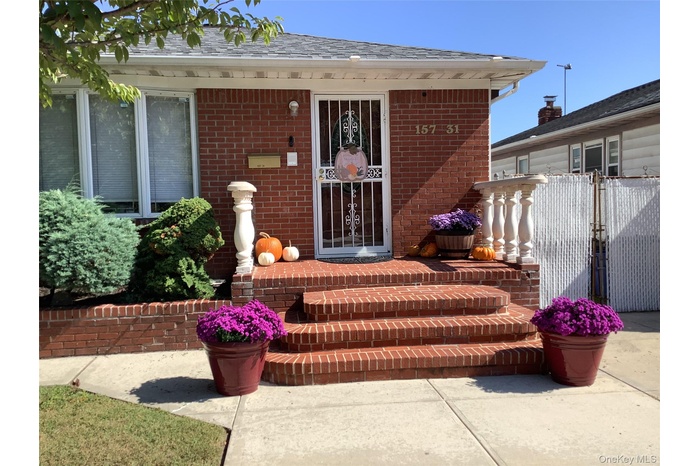 Entrance to property with brick siding and a shingled roof