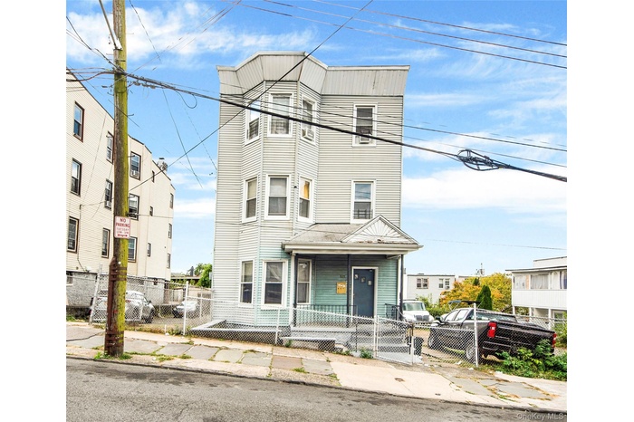 View of front facade featuring a fenced front yard and a gate