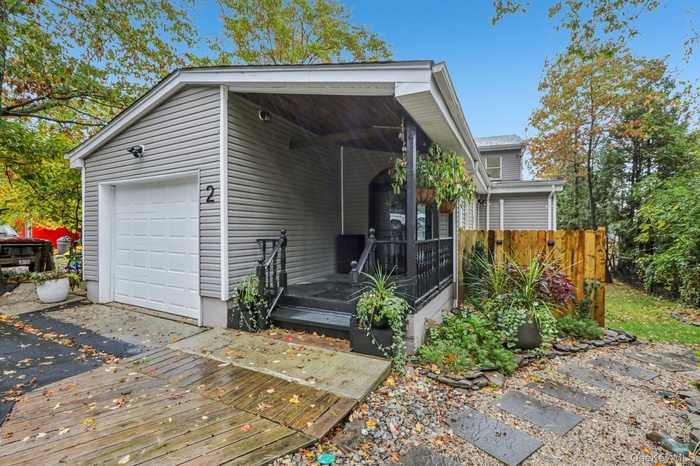 View of front of property featuring a wooden deck and a garage