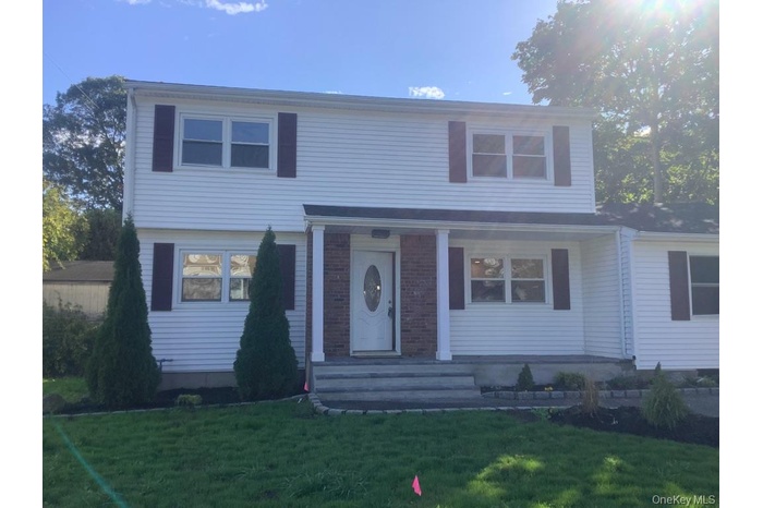 View of front facade with a front lawn and covered porch
