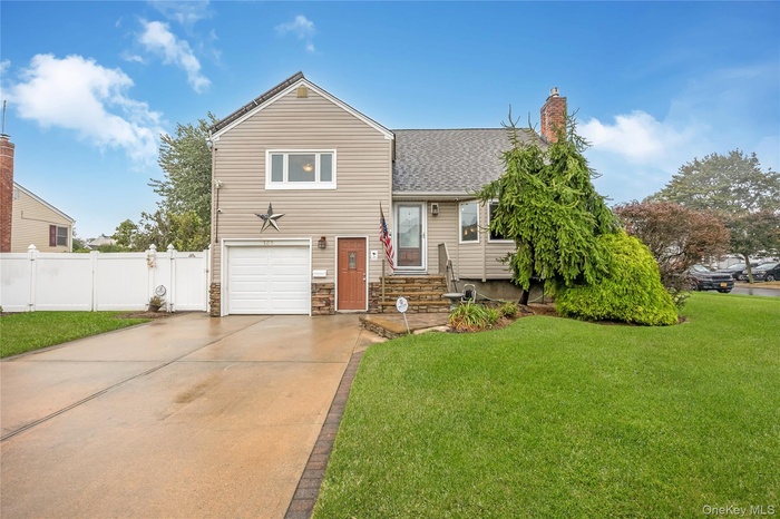 Tri-level home featuring concrete driveway, a garage, stone siding, roof with shingles, and a chimney