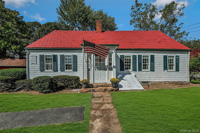 View of front of house with front entranceway distinctive red roof with shingles