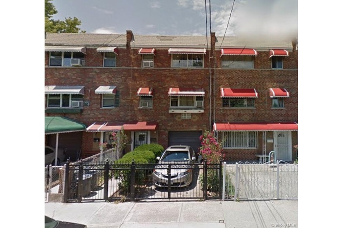 View of front of property featuring a fenced front yard, brick siding, and a gate