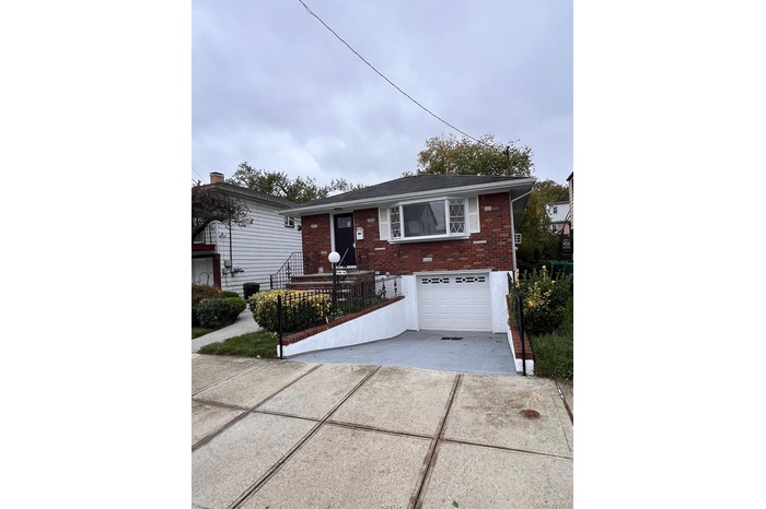 Single story home featuring brick siding, driveway, a garage, and a fenced front yard