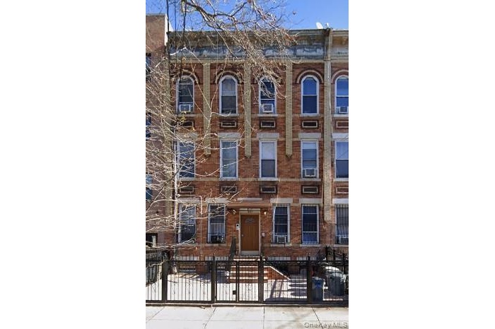 Italianate home featuring a fenced front yard and brick siding