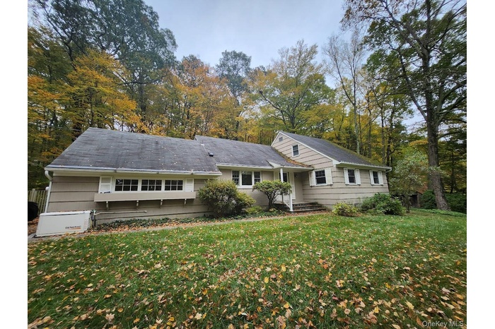 Rear view of house featuring a yard