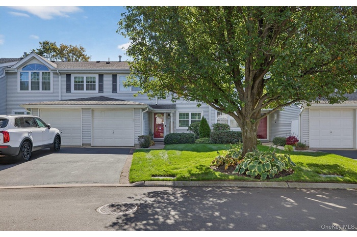 View of front of property with a front yard and driveway