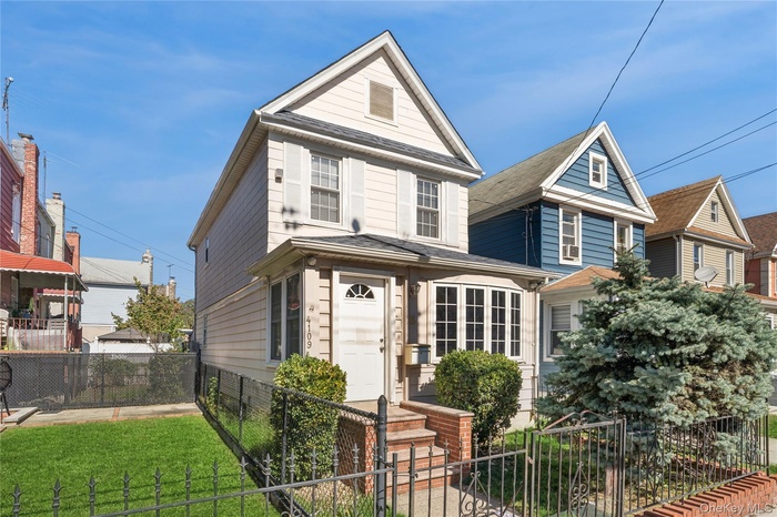 View of front of property featuring a fenced front yard and a gate