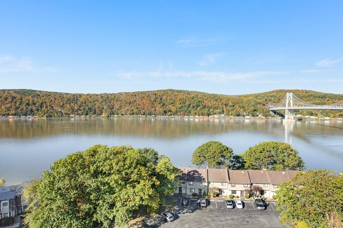 Water view featuring a heavily wooded area and a notable bridge