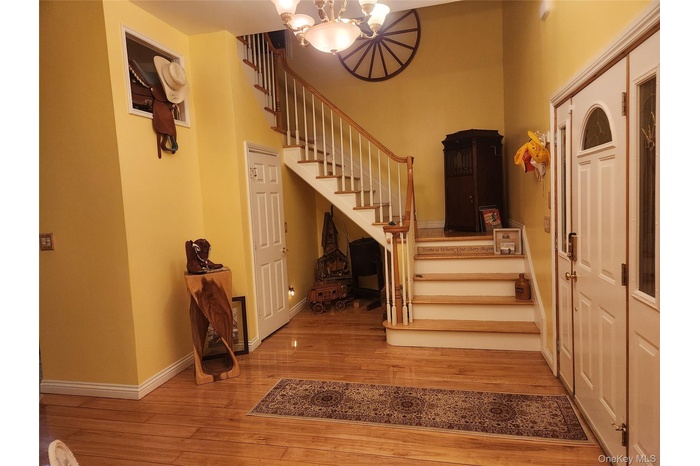 Entry Foyer Stairs with wood-type flooring and a notable chandelier